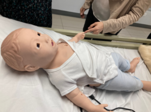 Demonstrating the functions of a high-fidelity pediatric mannequin that moves and cries, and realistically simulates health conditions such as difficulty of breathing and seizures